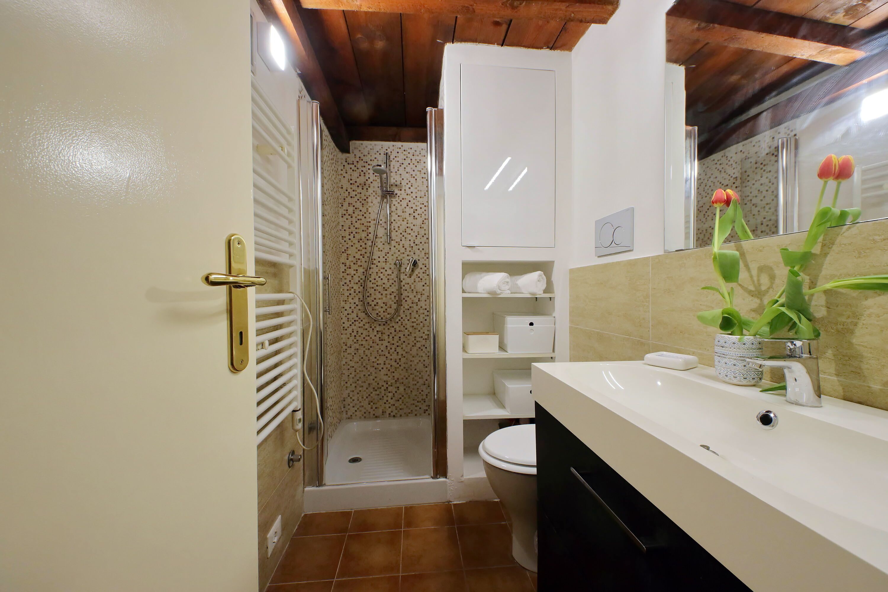 A bathroom with a shower, toilet, and sink.
