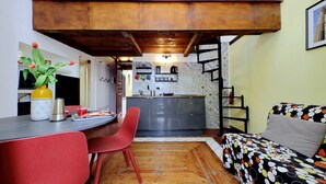 A compact living space with a kitchen, dining area, and a sofa. - 4BNB - Cozy Vatican Loft with Terrace (Roma)