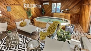 A wooden interior with a hot tub, seating area, and a sign reading "KILLINGTON".