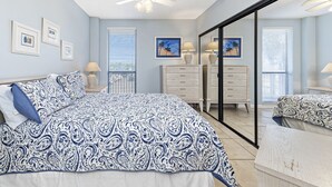 Un dormitorio con cama, cómoda, espejo y ventilador de techo.