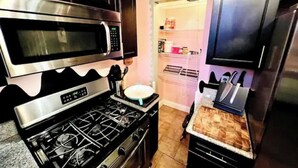 Una cocina equipada con estufa, microondas y refrigerador.