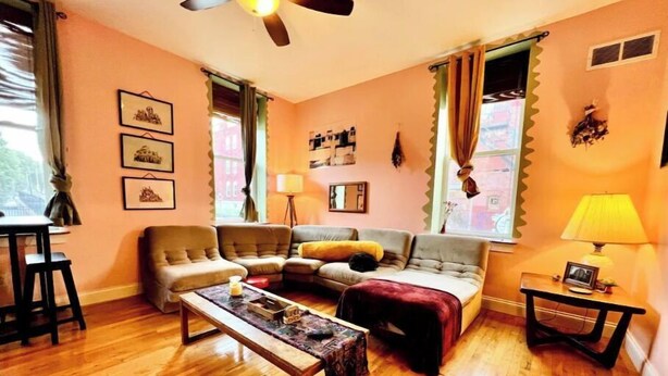 Una sala de estar con sofá, sillones, una mesa de centro y un ventilador de techo.