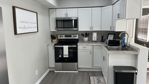 A modern kitchen with white cabinets, stainless steel appliances, and a granite countertop. - Entire beautiful home w/ great location!  (Paducah)