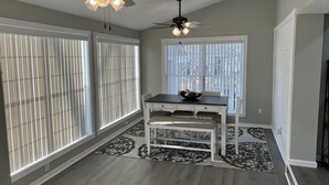 A spacious room with two ceiling fans, large windows with blinds, a dining table with chairs, and a patterned rug. - Entire beautiful home w/ great location!  (Paducah)