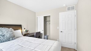 A bedroom with a bed, a desk, and a closet. - Modern 3BR Furnished Home Near DIA with 2-Car Garage (Denver)