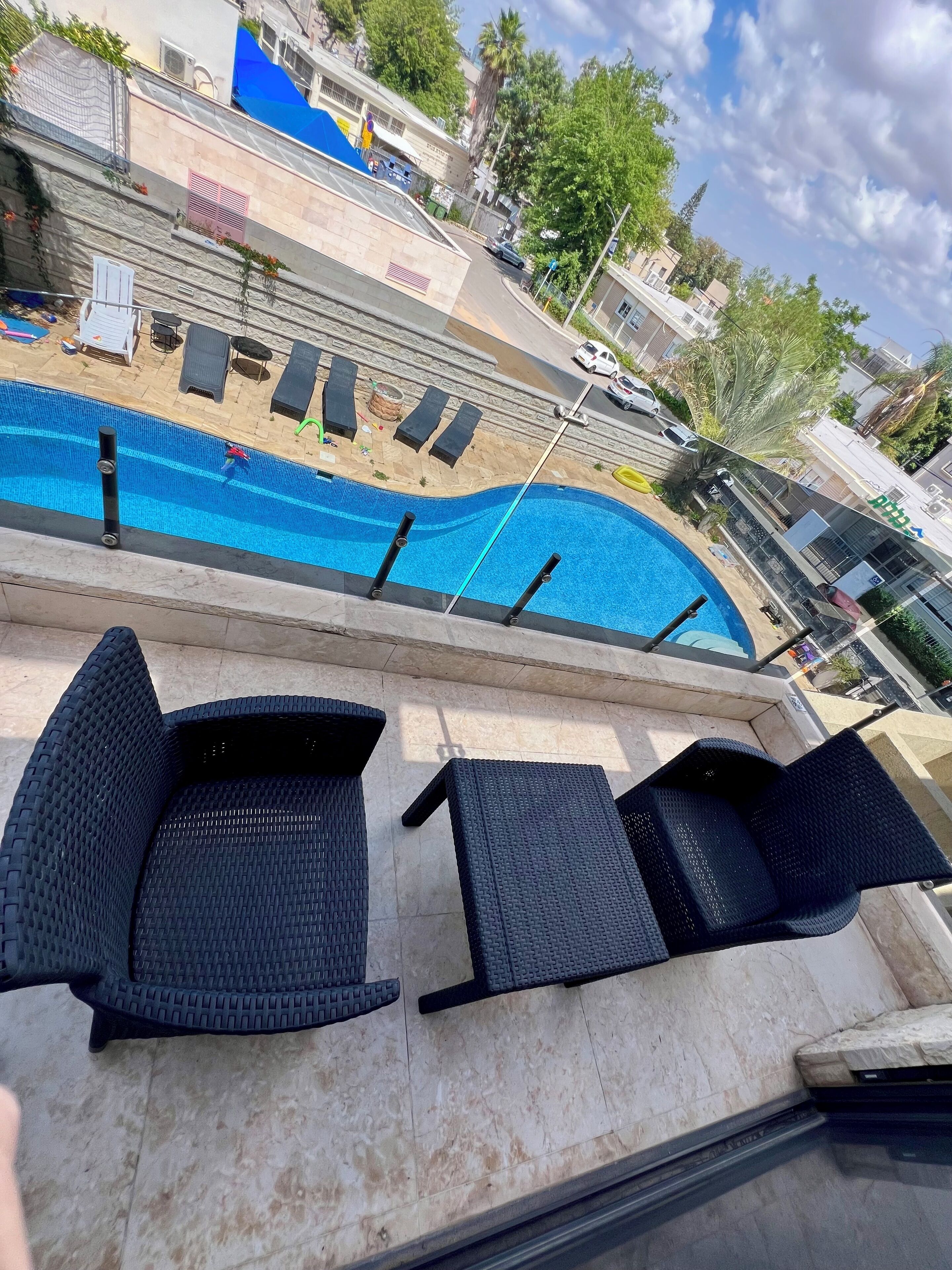Una piscina con sillas de descanso y una pared de piedra.