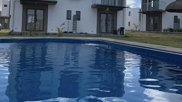 A modern two-story building with a swimming pool in front. - Visharm villa (Grand Gaube)