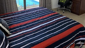 A bedroom with a bed, a desk, and a laptop. There is a window with curtains and a view of a swimming pool. - Visharm villa (Grand Gaube)
