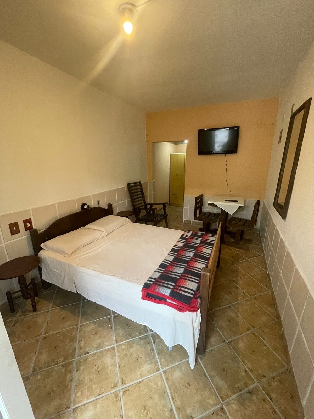 A hotel room with a bed, a television, a desk, and a chair.