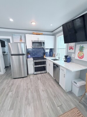 A modern kitchen with stainless steel appliances, a microwave, and a dishwasher. - Cozy spot next to Duval with swim spa - 2bed/2bath (Key West)