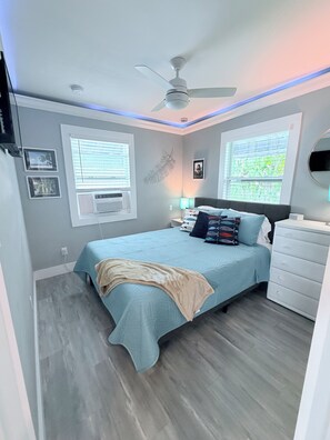 A bedroom with a bed, bedside tables, a ceiling fan, and windows. - Cozy spot next to Duval with swim spa - 2bed/2bath (Key West)