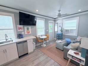 A compact living space with a kitchenette, dining area, and seating area.