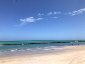 On the beach, white sand, sun loungers, beach umbrellas