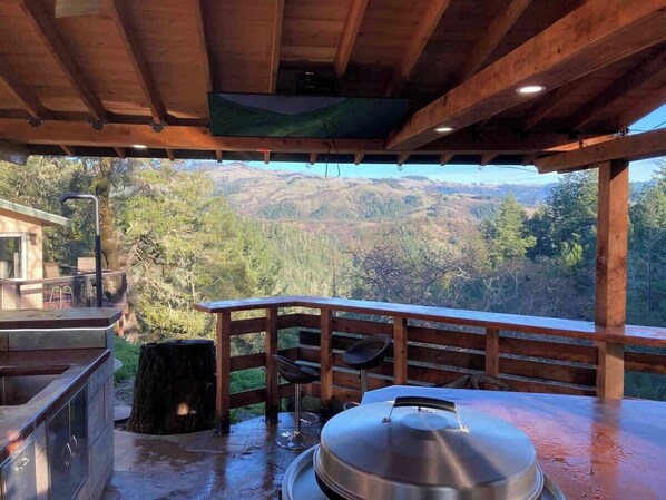 Ein Außenküchenbereich mit Blick auf eine gebirgige Landschaft.