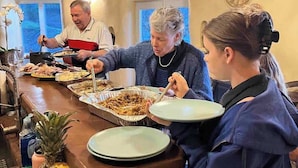 Un buffet proposant une variété de plats, un saladier rempli de fruits et un plafond en bois.