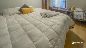 Ein Schlafzimmer mit einem großen Bett, einem Fenster und einer Tür.
