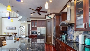 A modern kitchen with dark wood cabinets, stainless steel appliances, and a granite countertop. - Bigfoot Bungalow -Enjoy being directly on clear waters of the Weeki Wachee River (Weeki Wachee)