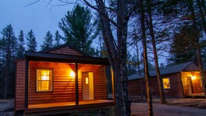 A wooden cabin with a front porch, large windows, and a door. - Cabin#2 at Northern Comfort w\opt side by side rentals (Atlanta)
