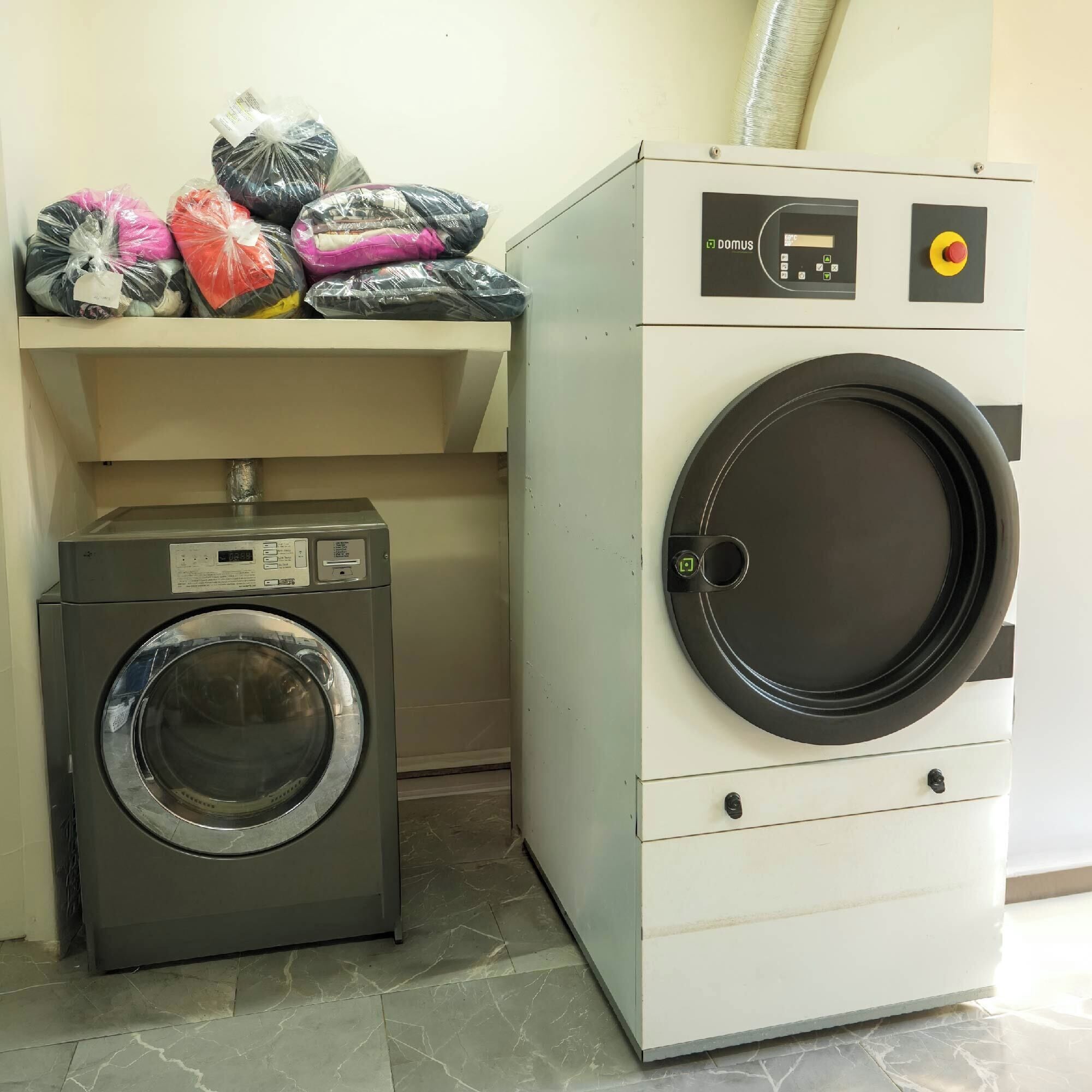 A front-loading washing machine and a top-loading dryer side by side in a laundry room.