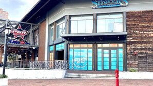 A waterfront restaurant with a prominent sign and a brick-paved entrance. - Historic Old Towne Southern Charm (Portsmouth)