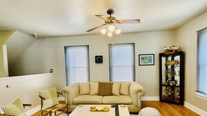 A living room with a sofa, chairs, a coffee table, and a ceiling fan. - Historic Old Towne Southern Charm (Portsmouth)
