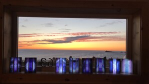 Une pièce dotée d’une grande fenêtre donnant sur un magnifique coucher de soleil sur l’océan.