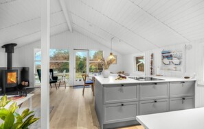 A modern kitchen with a central island, a built-in stove, and a large window. - 3 bedroom awesome home in Esbjerg V (Esbjerg V)