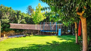 A backyard with a trampoline, a swing set, and a tree. - 5 bedroom lovely home in Rians (Rians)