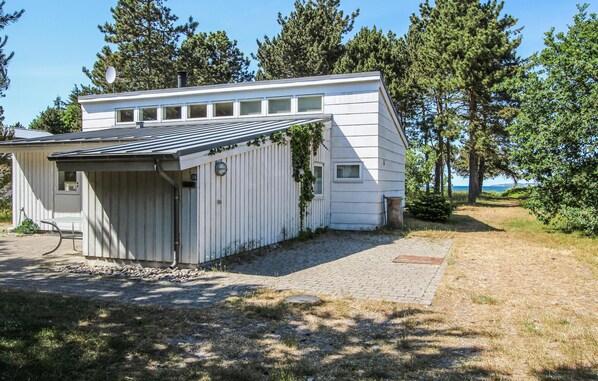 A single-story house with a sloped roof, a small attached garage, and a paved driveway leading to the entrance. - Stunning home in Samsø with WiFi (Samsø)