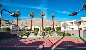 Enjoy a game of tennis with a scenic view of the surrounding area and nearby mountains.