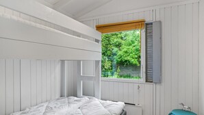 A bedroom with a bunk bed, a window with shutters, a radiator, and a small stool. - Nice home in Tisvildeleje with WiFi (Tisvildeleje)