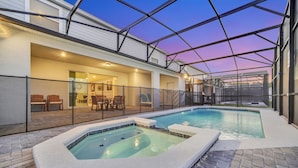 Un espace piscine sur le toit, doté d’un jacuzzi et d’un patio couvert avec des sièges.