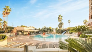 A resort pool area with lounge chairs, a restaurant, and palm trees. - 1 bedroom beautiful apartment in Cannes (Cannes)