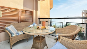 A balcony with wicker furniture, a glass table, and a bottle of wine. - 1 bedroom beautiful apartment in Cannes (Cannes)