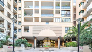 A multi-story hotel with a central entrance, balconies, and a reception area with a planter. - 1 bedroom beautiful apartment in Cannes (Cannes)