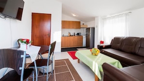 Un espacio habitable pequeño con comedor, kitchenette y sofá.