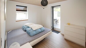 A bedroom with a bed, a window, a door, and a white dresser. - Beautiful home in Samsø with WiFi (Samsø)