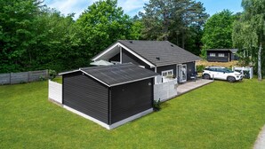 A modern two-story house with a garage, a covered patio, and a car parked in the driveway.