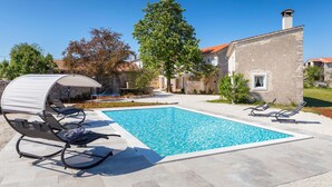A swimming pool with lounge chairs and a covered seating area. - Awesome home in Modrusani (Modrusani)