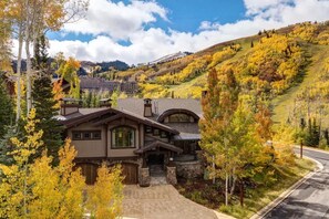A large, multi-story building with a stone facade, a prominent entrance, and a driveway leading to the main entrance. - Abode at Northside, ski-in/ski-out, hot tub, mountain views (Park City)