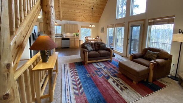 A spacious living area with a high ceiling, wooden beams, and large windows. - Pool-Table Game Room, Darts & Starlink - Pet-Friendly, Mtn Views (Fairplay)