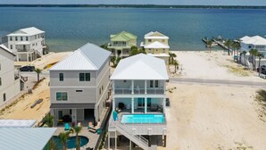 Une propriété située en bord de mer, dotée d’une grande piscine, de plusieurs balcons et offrant une vue sur l’océan.