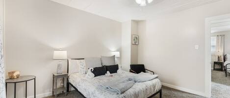 A bedroom with a bed, bedside tables, a lamp, and a ceiling fan.