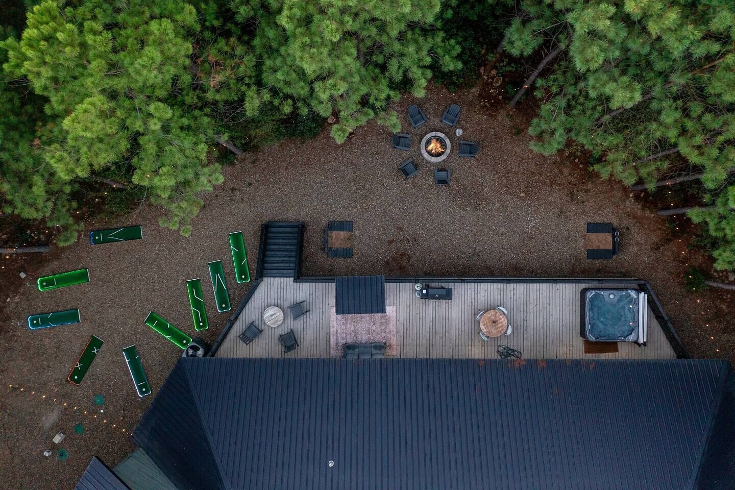 Vista aérea de una terraza en la azotea con una chimenea, asientos y un jacuzzi.