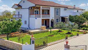 A two-story house with a balcony, a stone facade, and a well-maintained garden. - Gorgeous apartment in Vrsi with WiFi (Vrsi)