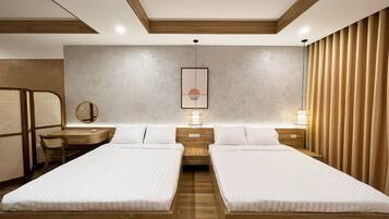 A modern hotel room with two beds, a desk, and a chair.