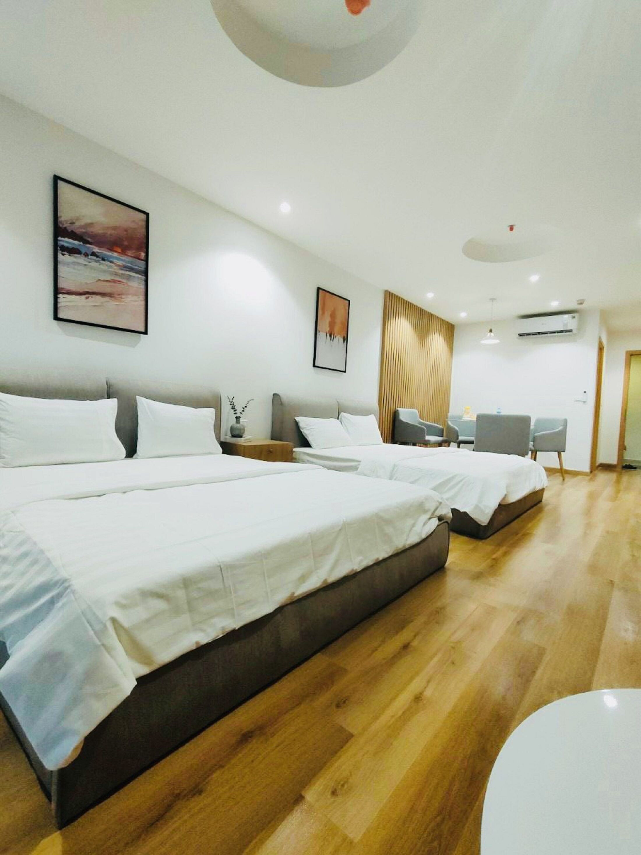 Quarto de hotel moderno com uma cama grande, uma mesa e uma cadeira.