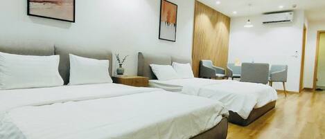 Quarto de hotel moderno com uma cama grande, uma mesa e uma cadeira.