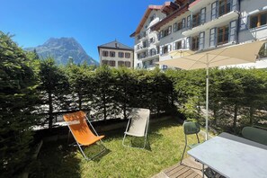 Une terrasse avec des meubles d’extérieur, une table et une vue sur une montagne.