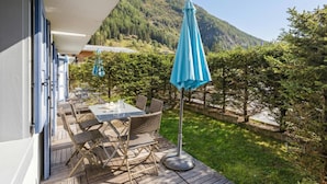 Une terrasse dotée de mobilier d’extérieur et offrant une vue sur la montagne.